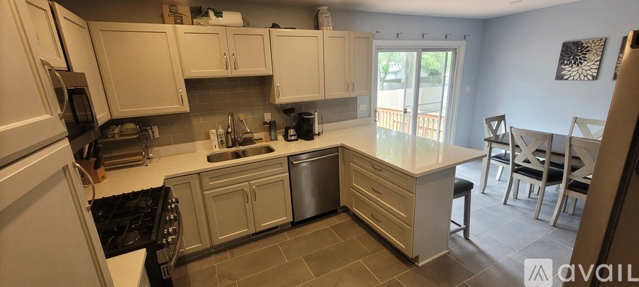 A kitchen with white cabinets and a large island.