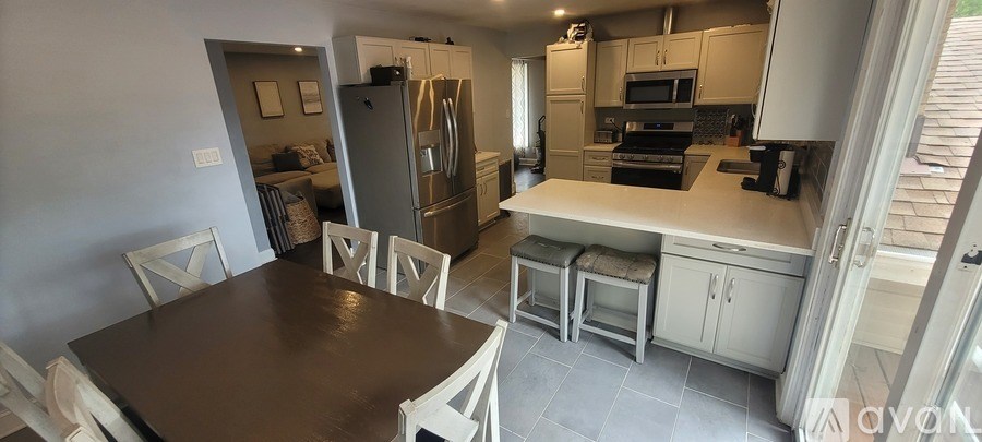 A kitchen with a table and chairs in front of it.