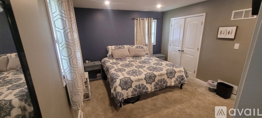A bedroom with two beds and a carpeted floor.