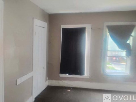 A room with a window and a door is available for rent.