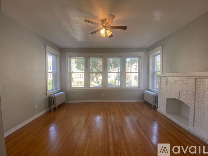A room with wooden floors and a fireplace is available for rent.