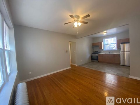 A room with wooden floors and a ceiling fan.
