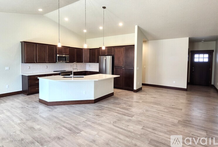 A kitchen with a white island and wooden floors.