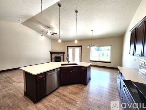A kitchen with dark wood cabinets and a white countertop.
