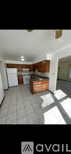 A kitchen with white appliances and brown cabinets.