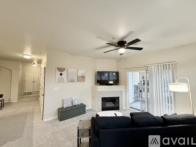 A living room with a couch, a fireplace, and a television.