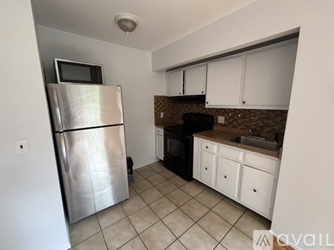 A kitchen with a refrigerator, oven, and cabinets.