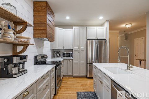 A kitchen with a white counter top and wooden cabinets.