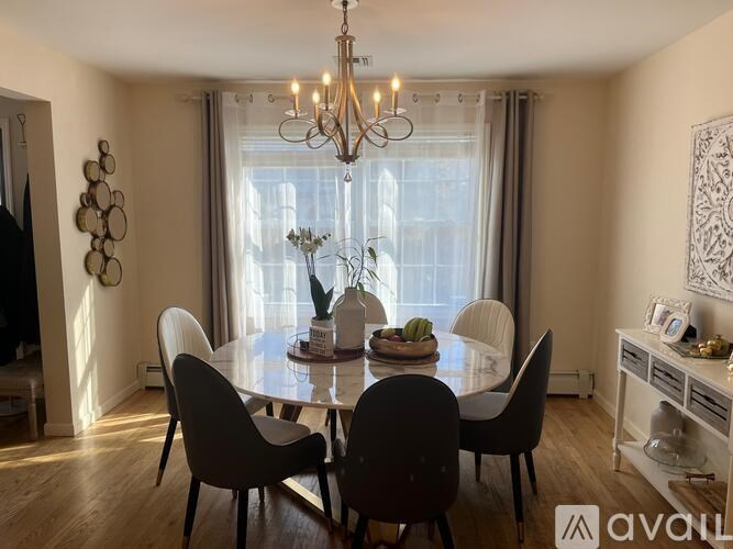 A dining room with a round table and chairs.