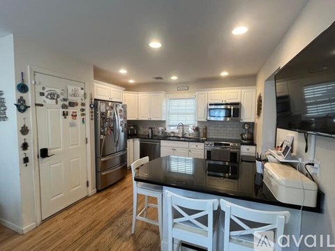 A kitchen with white cabinets and a black countertop.