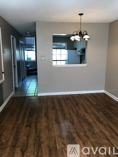 A room with wooden floors and a chandelier.
