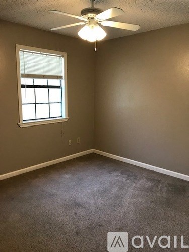 A room with a ceiling fan and a window.