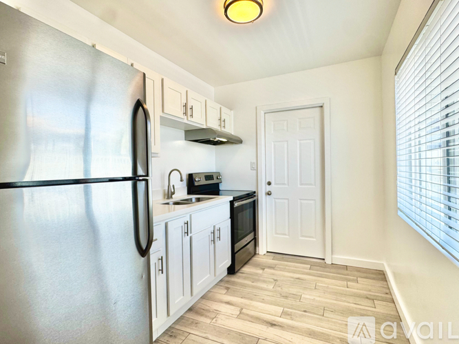 A kitchen with a refrigerator, microwave, and oven.