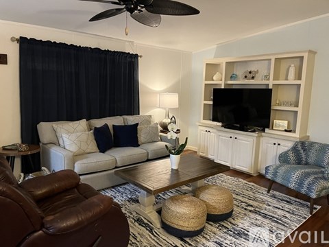 A living room with a brown leather chair and a white couch.