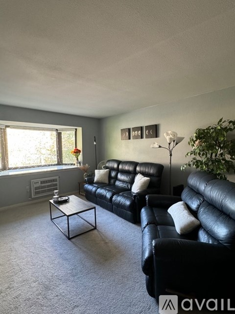 A living room with a black leather couch and a coffee table.