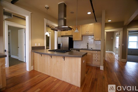 A kitchen with wooden floors and a large island.