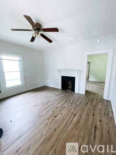 A room with a fireplace and a ceiling fan.