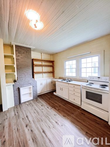 A kitchen with wooden floors and white appliances.