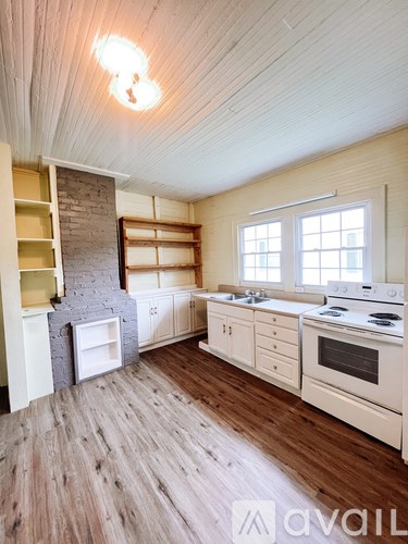 A kitchen with wooden floors and white appliances.