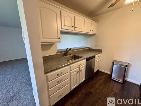 A kitchen with white cabinets and a granite countertop.