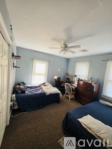 A bedroom with two beds and a dresser.