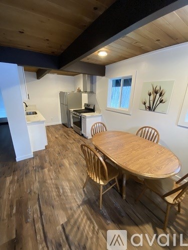 A dining room with a wooden table and chairs.