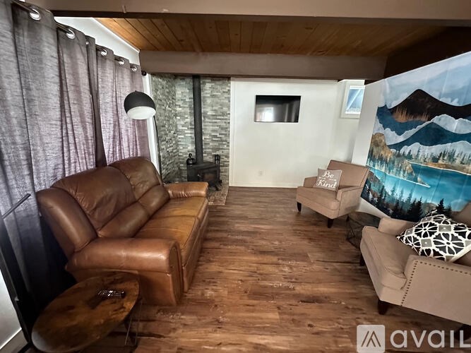 A living room with a brown leather sofa and a wooden table.