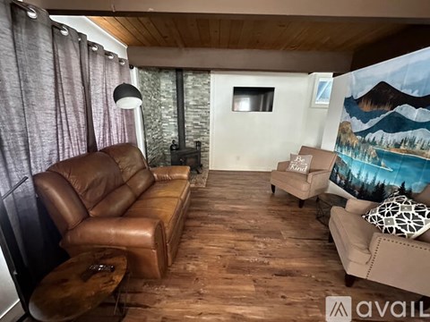 A living room with a brown leather sofa and a wooden table.