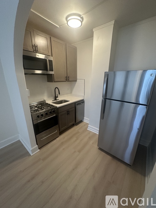A kitchen with a refrigerator, stove, and sink.