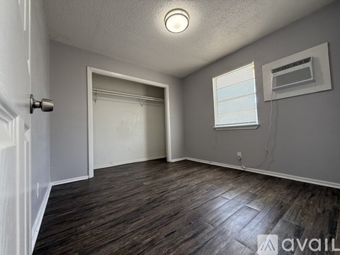 A room with a door, window, and a wall-mounted air conditioner unit.