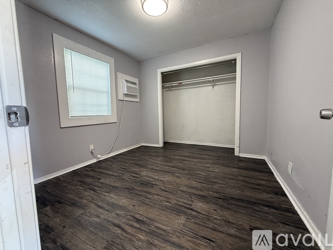 A room with wooden flooring and a window.
