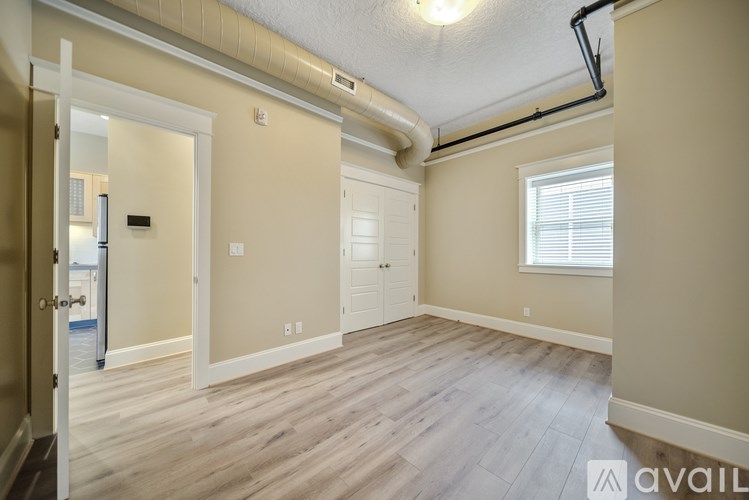 A room with a window and a door leading to another room.