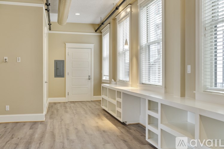 A room with a white door and a window with blinds.