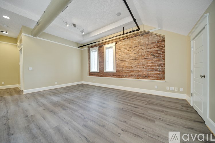 A room with a brick wall and wooden flooring.