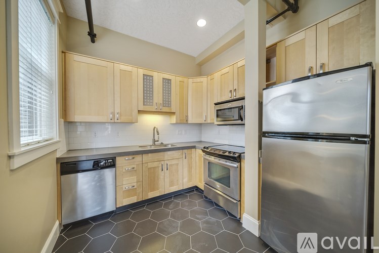 A kitchen with wooden cabinets and a stainless steel refrigerator.