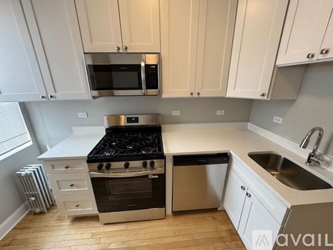 A kitchen with white cabinets and a stainless steel oven.
