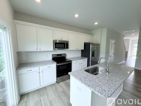 A kitchen with white cabinets and a granite countertop.