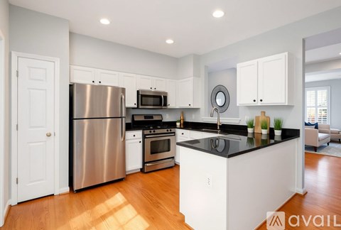 A modern kitchen with white cabinets and stainless steel appliances.