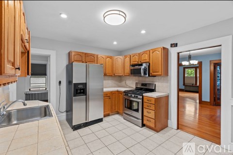 A kitchen with wooden cabinets and a stainless steel refrigerator.