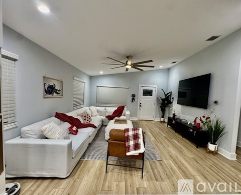A living room with a white couch and a ceiling fan.