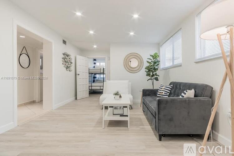 A living room with a grey couch, a white coffee table, and a wooden floor.