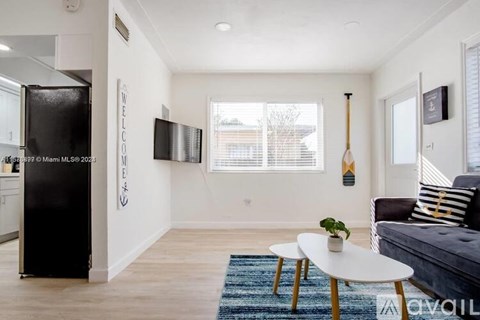 A living room with a couch, a table, and a TV.