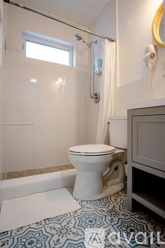 A white toilet in a bathroom with a patterned floor.