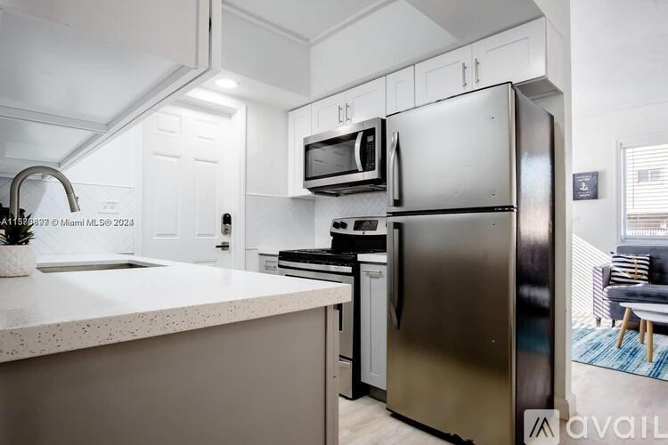 A modern kitchen with a stainless steel refrigerator and microwave above the stove.