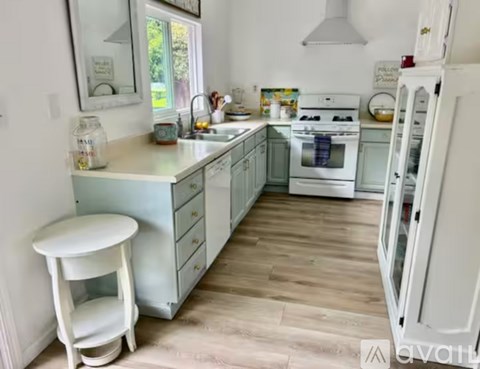 A kitchen with white and blue cabinets and a wooden floor.