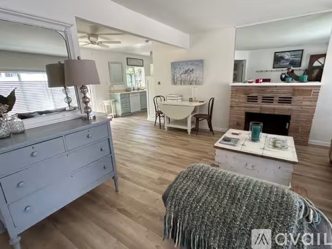 A grey dresser with a mirror and a lamp on top of it.