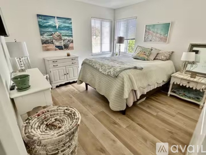 A bedroom with a bed, dresser, and a painting on the wall.