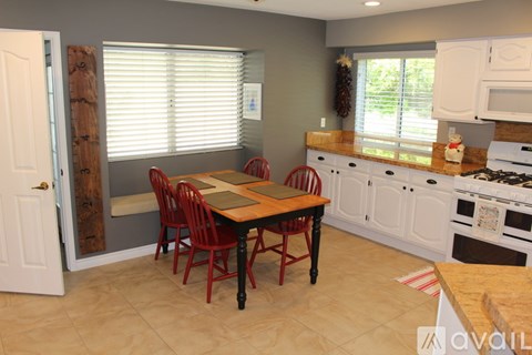 A kitchen with a table and chairs in the middle of the room.