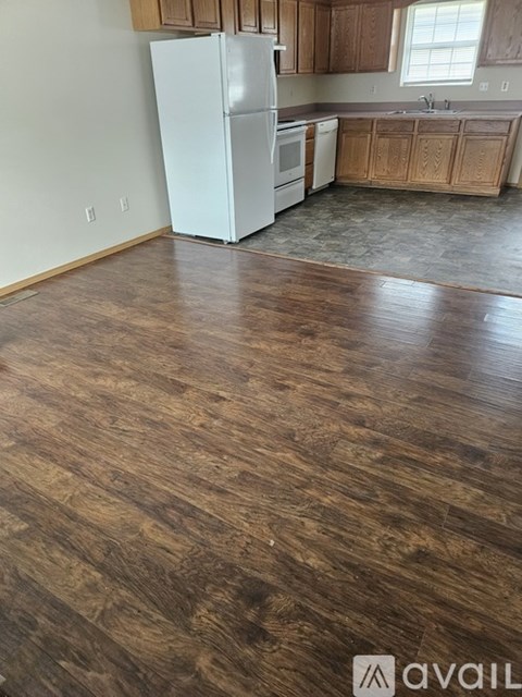A kitchen with wooden cabinets and a white fridge.