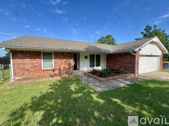 A house with a driveway and a tree in front of it.